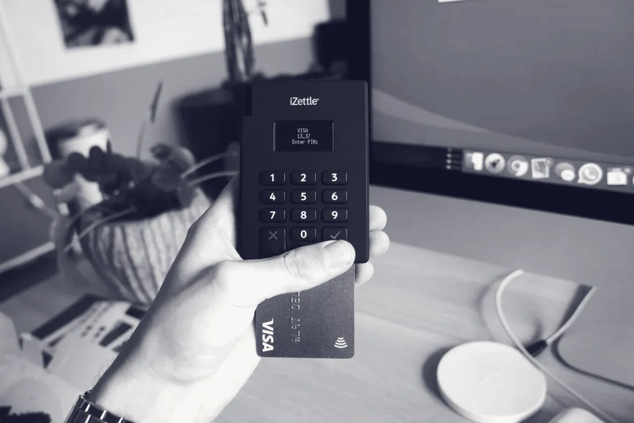 Cardholder tapping a contactless card on a payment terminal